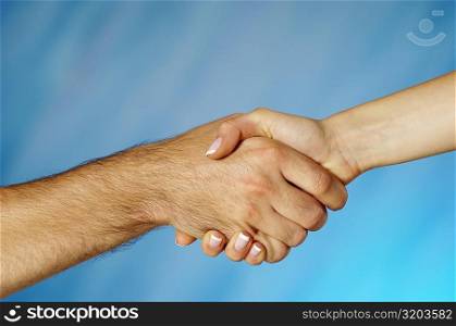 Close-up of a man and a woman shaking hands