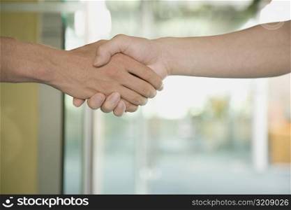 Close-up of a man and a woman shaking hands