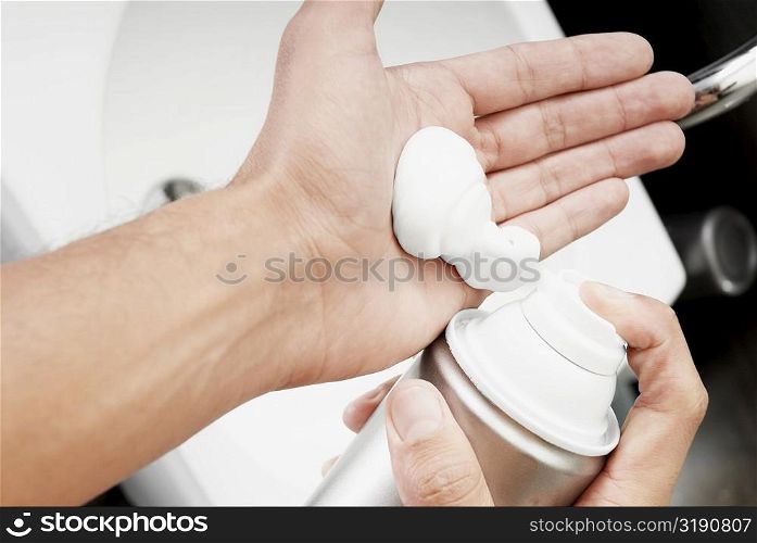 Close-up of a man applying shaving cream on his hand