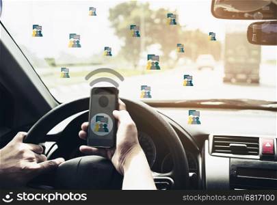 Close up of a man driving car dangerously while chating on mobile phone