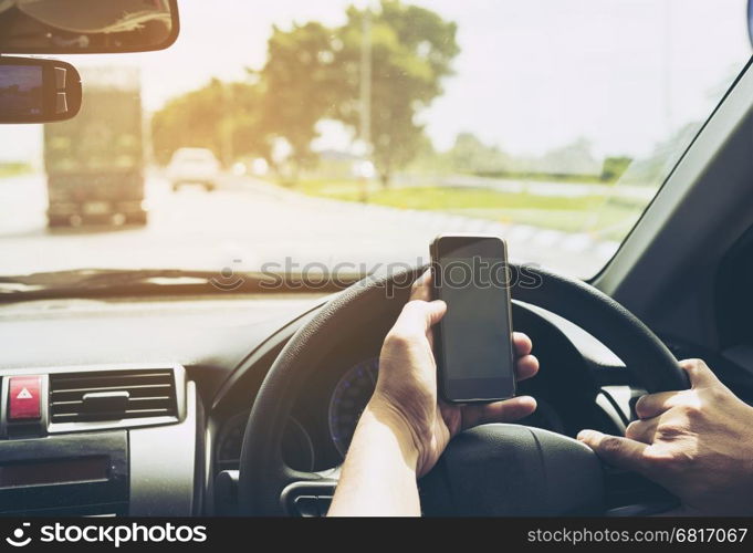 Close up of a man driving car dangerously while using mobile phone