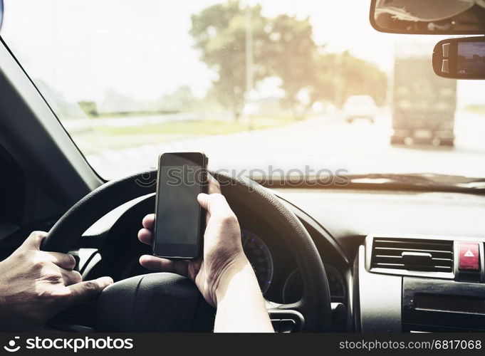 Close up of a man driving car dangerously while using mobile phone