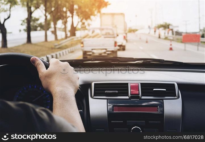 Close up of a man driving car using one hand, dangerous behavior