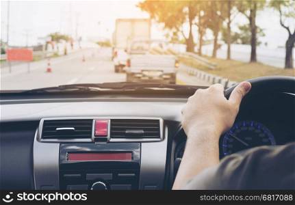 Close up of a man driving car using one hand, dangerous behavior