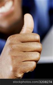 Close-up of a man giving a thumbs up sign