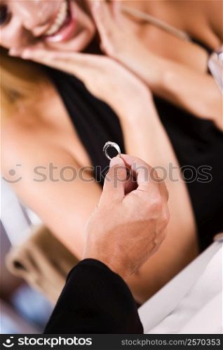 Close-up of a man giving an engagement ring to a young woman