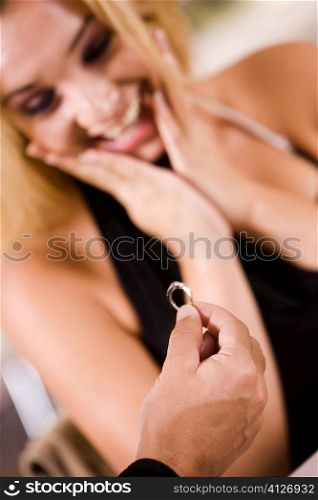 Close-up of a man giving an engagement ring to a young woman