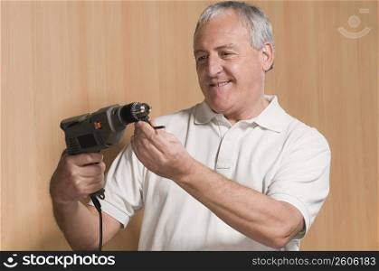 Close-up of a man holding a drill and smiling