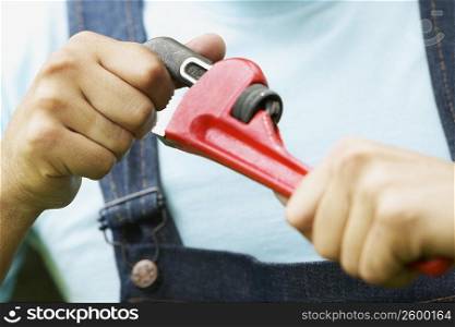 Close-up of a man holding an adjustable wrench
