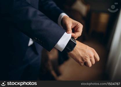 Close-up of a man in a tux fixing his cufflink. groom bow tie cufflinks.. Close-up of a man in a tux fixing his cufflink. groom bow tie cufflinks