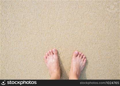 Close Up of a man&rsquo;s bare feet stand at wet on the beach , with a sand edge gently beneath them. Vacation on ocean beach, foot on sea sand. Leave empty copy space Enter the text above.