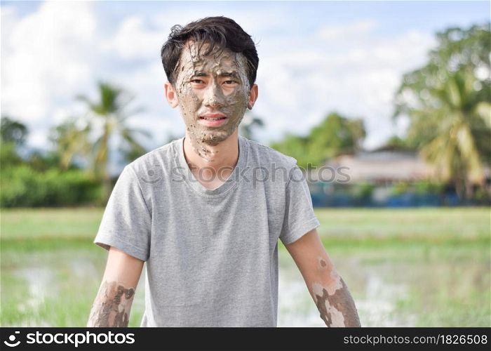 Close up of a man&rsquo;s face and hands covered in mud