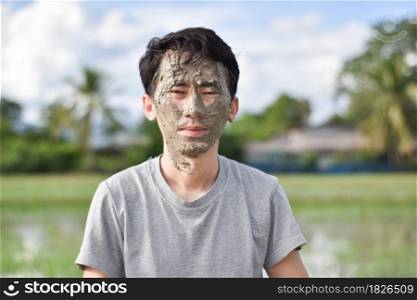 Close up of a man&rsquo;s face and hands covered in mud
