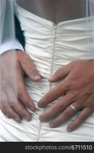 Close up of a mans hands on a woman&acute;s back