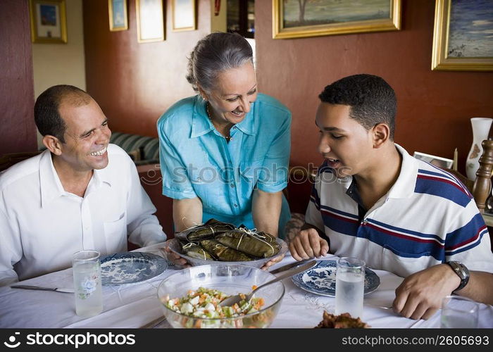 Close-up of a mature couple and their son sitting at the dining table