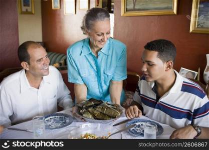 Close-up of a mature couple and their son sitting at the dining table