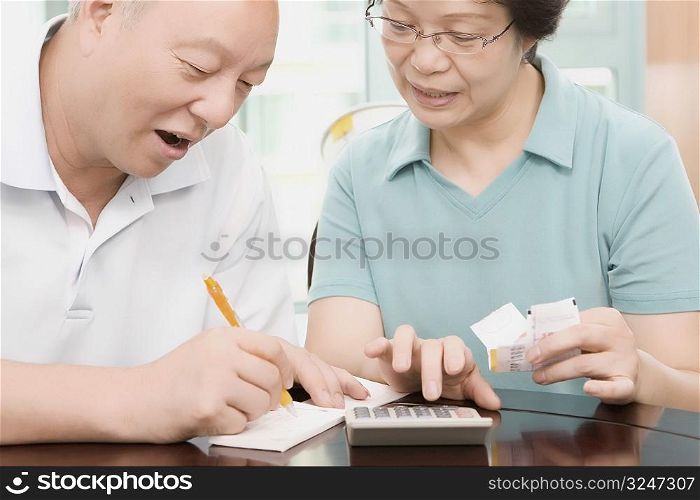 Close-up of a mature couple calculating bills