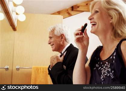 Close-up of a mature couple dressing up in the bathroom and laughing