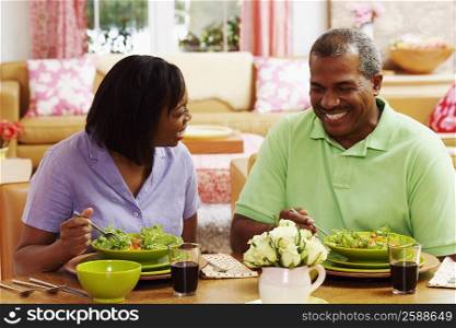 Close-up of a mature couple eating salad and smiling