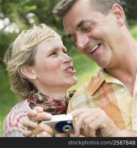 Close-up of a mature couple holding a digital camera