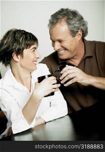 Close-up of a mature couple holding cups of coffee and looking at each other