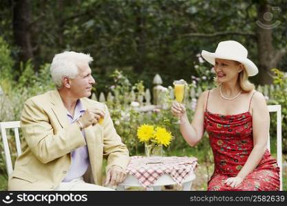 Close-up of a mature couple holding glasses of juice