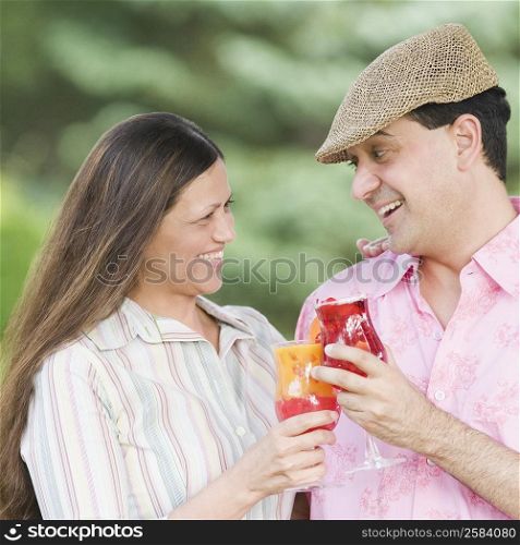 Close-up of a mature couple holding glasses of juice and smiling