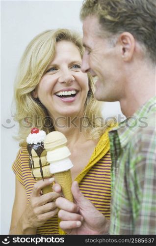 Close-up of a mature couple holding ice cream cones and smiling