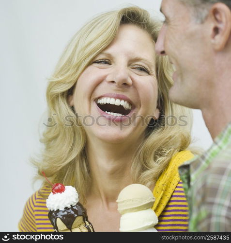 Close-up of a mature couple holding ice cream cones and smiling