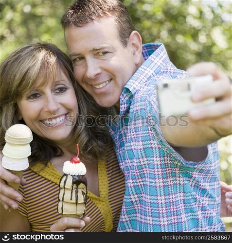 Close-up of a mature couple holding ice cream cones and taking a picture of themselves