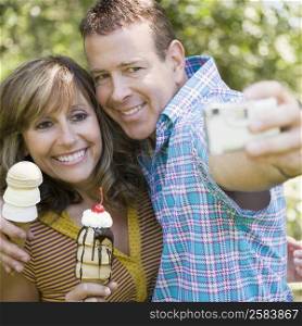 Close-up of a mature couple holding ice cream cones and taking a picture of themselves