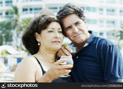 Close-up of a mature couple holding wine glasses and looking away