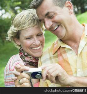 Close-up of a mature couple looking at a digital camera and smiling
