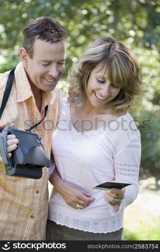 Close-up of a mature couple looking at a photograph and smiling