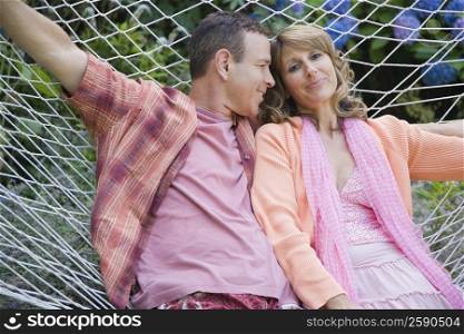 Close-up of a mature couple lying in a hammock and smiling