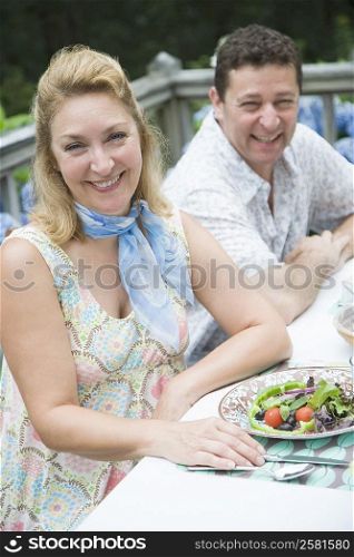 Close-up of a mature couple sitting at the dinning table and smiling