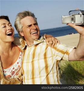 Close-up of a mature couple taking a picture of themselves on the beach