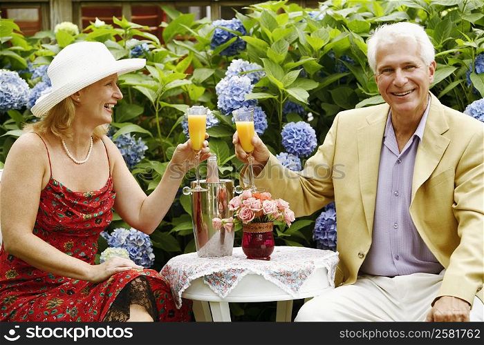 Close-up of a mature couple toasting glasses of juice