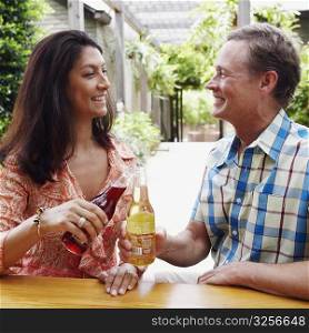 Close-up of a mature couple toasting with beer bottles