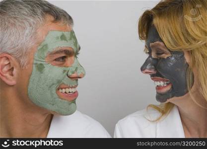 Close-up of a mature couple wearing facial masks and smiling
