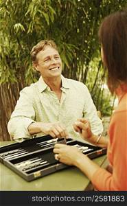 Close-up of a mature man and a mature woman playing backgammon
