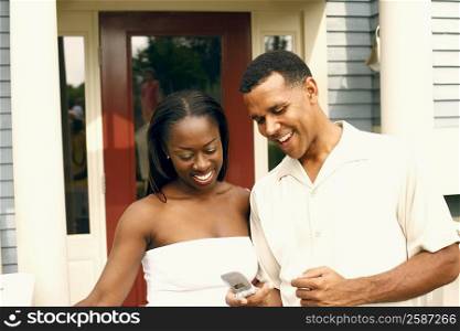 Close-up of a mature man and a mid adult woman looking at a mobile phone
