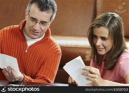 Close-up of a mature man and a mid adult woman looking at photographs