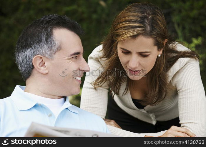 Close-up of a mature man and a mid adult woman reading a newspaper