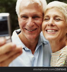 Close-up of a mature man and a senior woman taking a picture of themselves