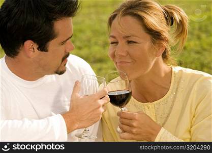 Close-up of a mature man and a young woman toasting with wine