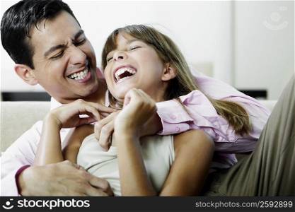 Close-up of a mature man and his daughter playing