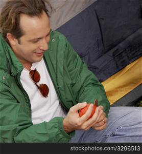 Close-up of a mature man cutting an apple