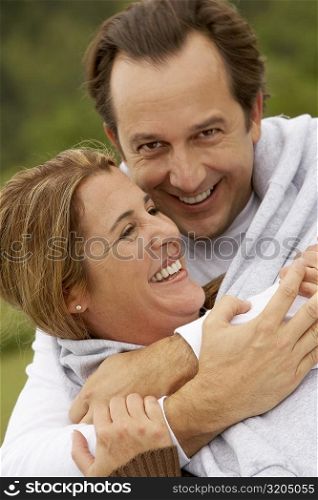 Close-up of a mature man embracing a mid adult woman