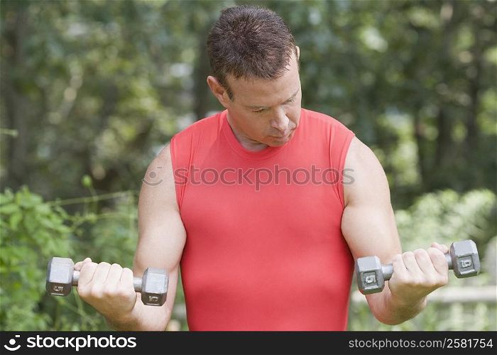 Close-up of a mature man exercising with dumbbells